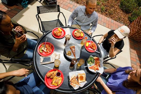 Students eat and chat outside at Fresh Food Company